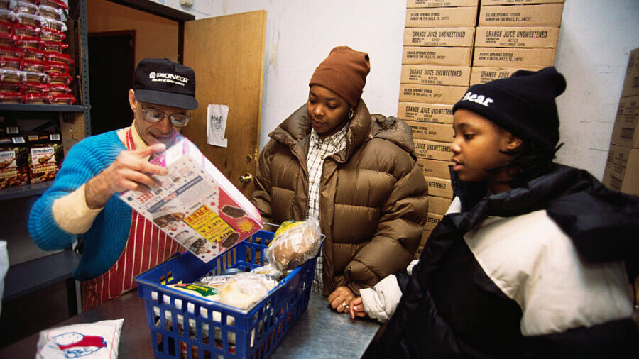 A food bank volunteer prepares a free food basket of two young women in New York. (Photo by © Vivi...